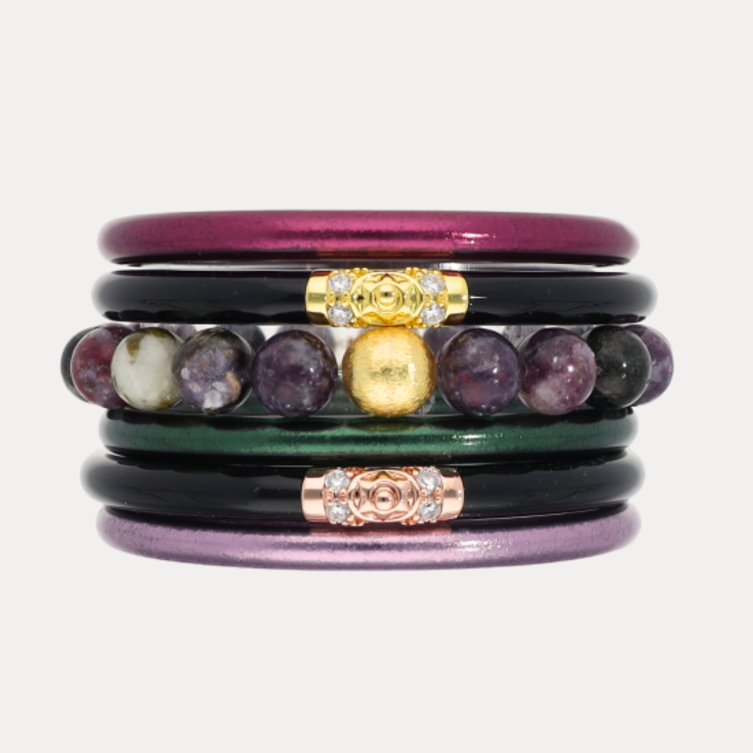 Stack of colorful bracelets with gemstones and metal accents on a white background