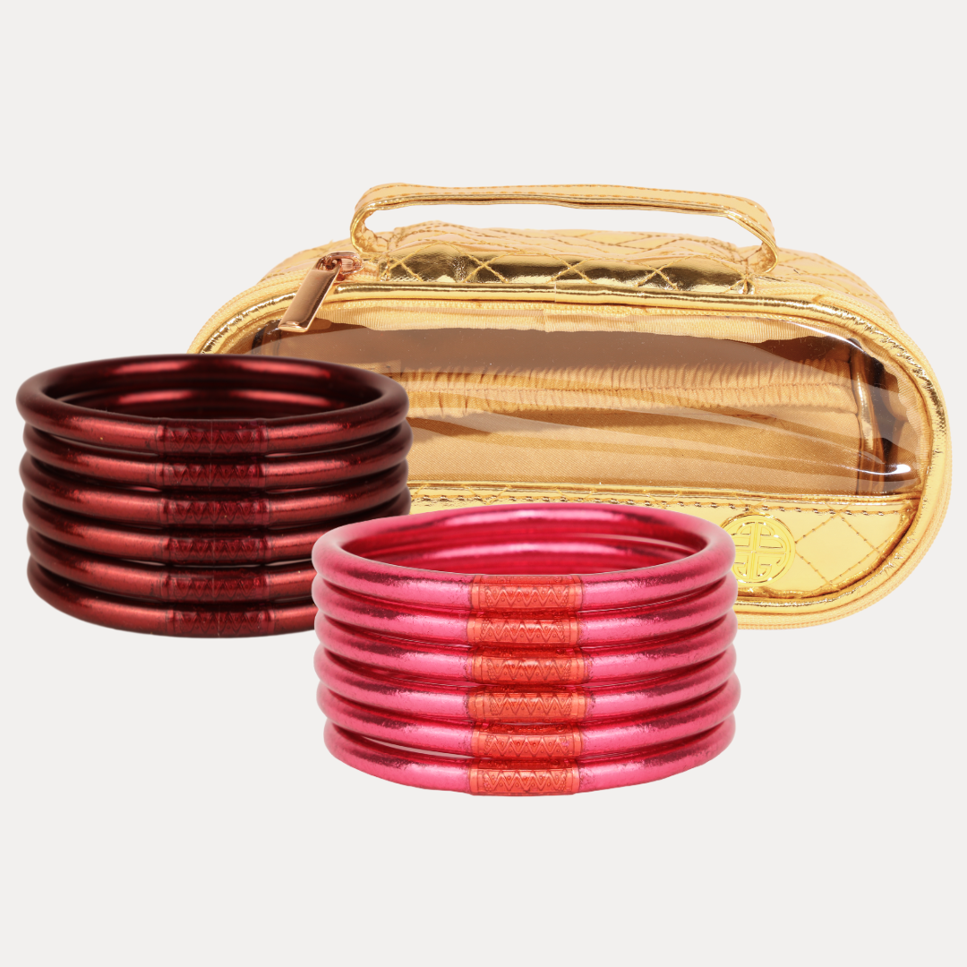 Set of red bangles with a gold case on a white background